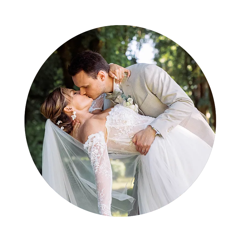 les mariés qui s'embrassent dans les jardins du Château