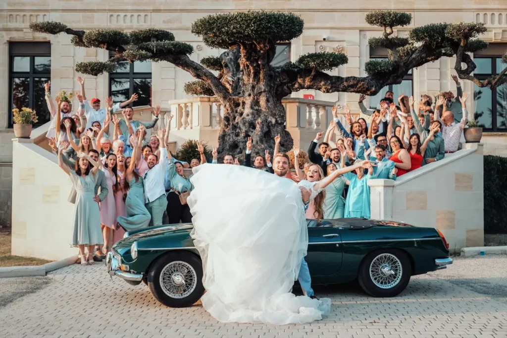Mariés célébrant devant une voiture de collection