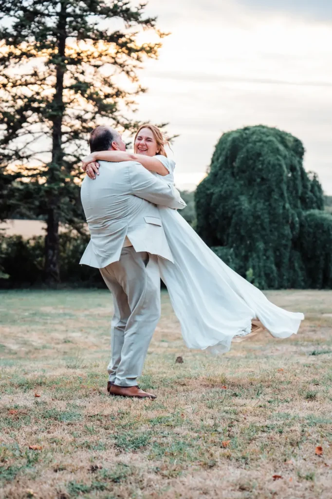 Marié portant la mariée dans le jardin
