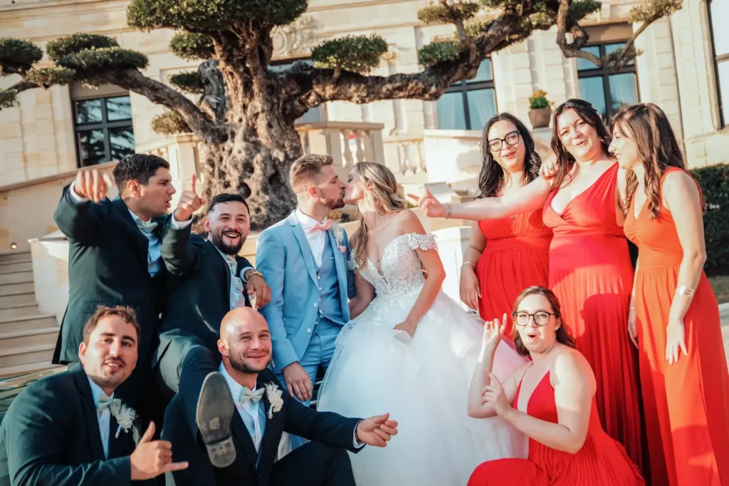 Photo de groupe des temoins célébrant le mariage au château avec les mariés devant le château