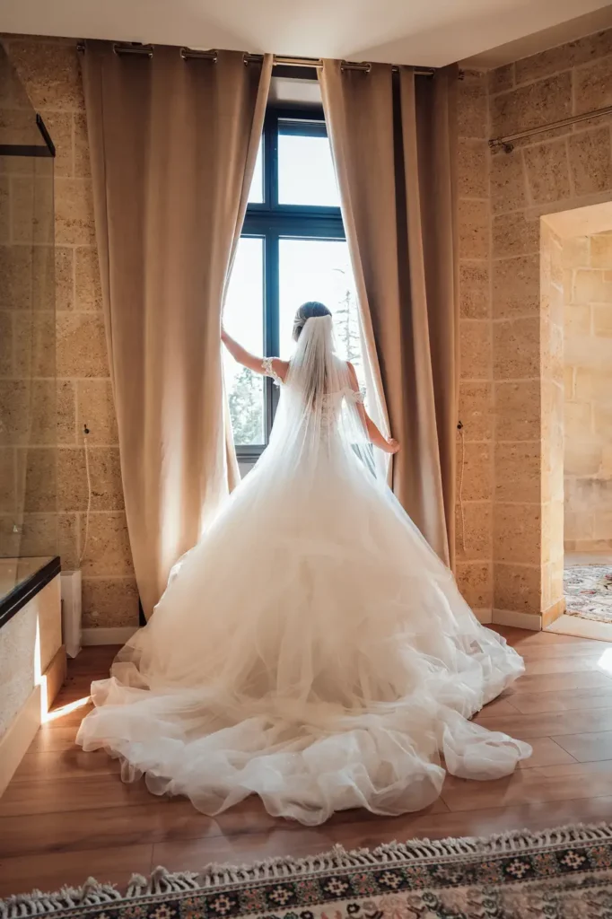 Robe de mariée devant une grande baie vitrée