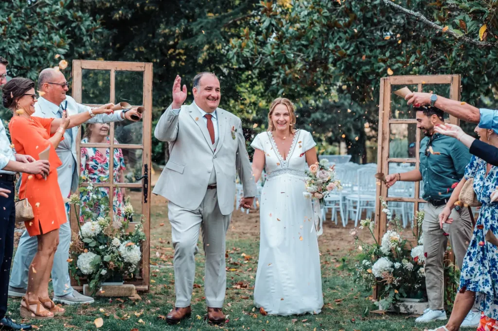 Sortie des mariés sous les applaudissements et les pétales de fleurs