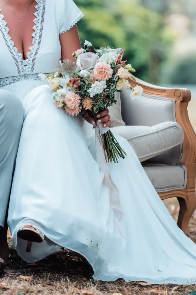 Bouquet de mariée posé sur une robe blanche