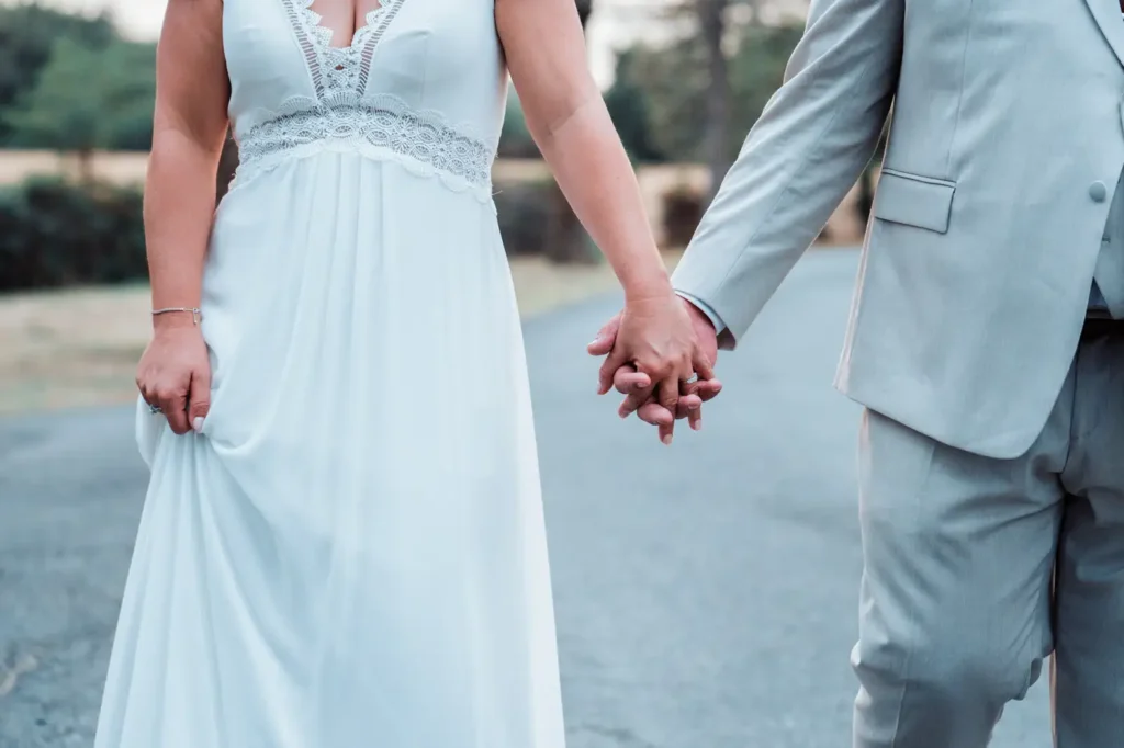 Détail des mains des mariés se tenant la main