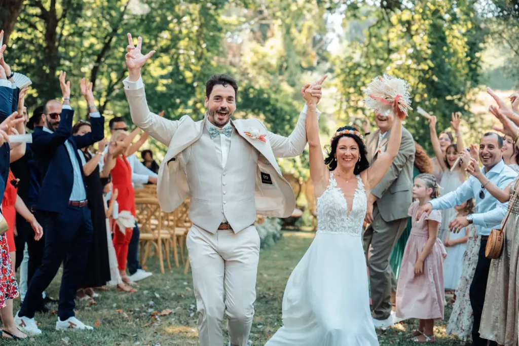 Sortie des mariés entourés de leurs invités lors d’un mariage en extérieur