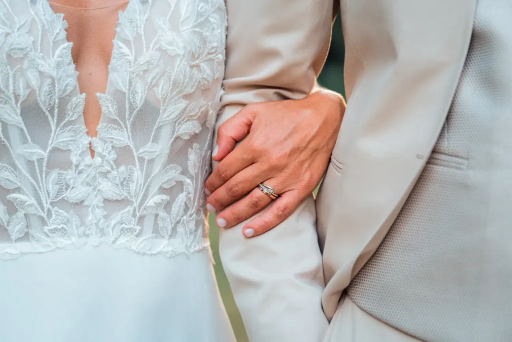 Bras enlacés des mariés avec alliance visible en Gironde