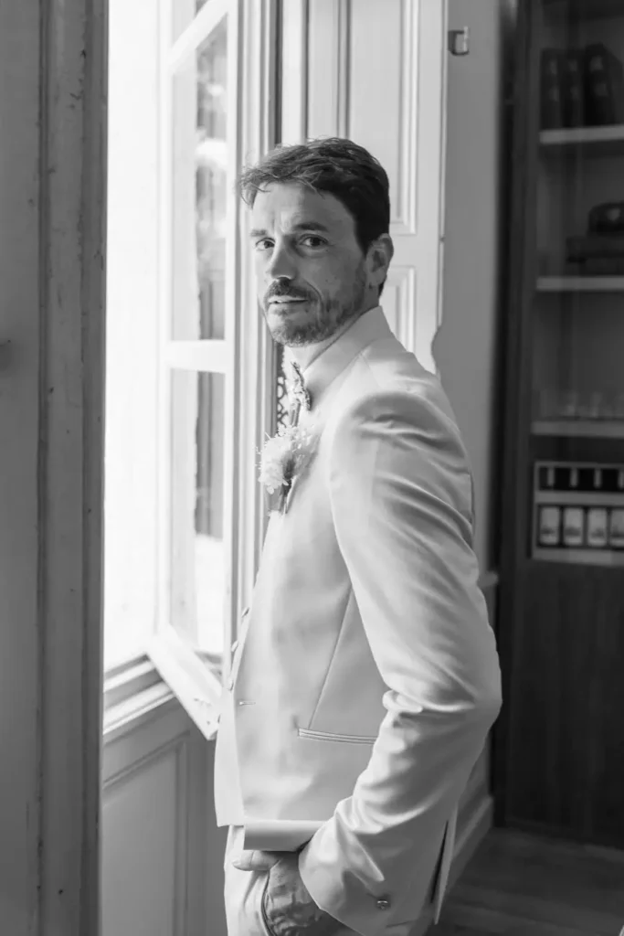 Portrait du marié près d’une fenêtre à Portets