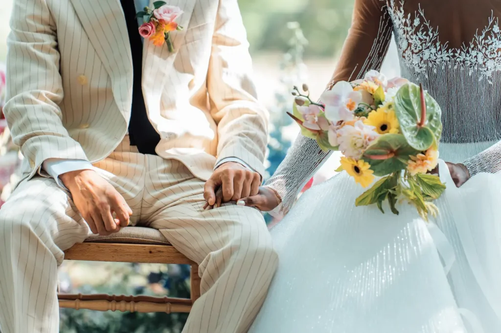 Détail des mains des mariés tenant leur bouquet au Château Sénéjac