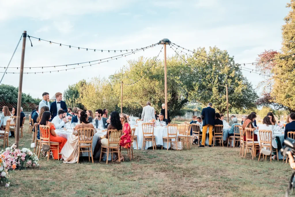 Repas de mariage en plein air sous guirlandes lumineuses