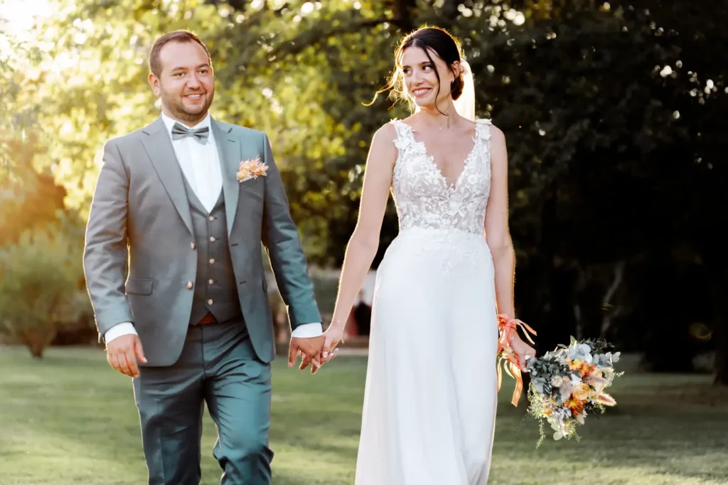 Mariés marchant main dans la main au Domaine de Ségur