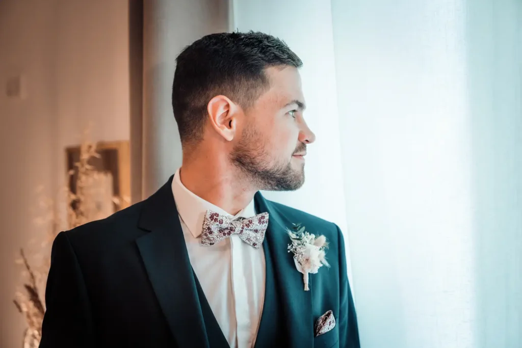 Portrait du marié en costume dans la chambre du domaine