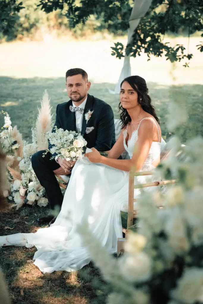 Portrait des mariés assis dans le parc