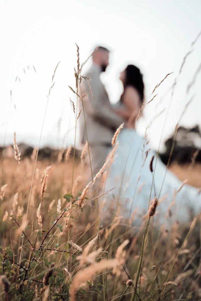 Mariés dans un champ au coucher du soleil