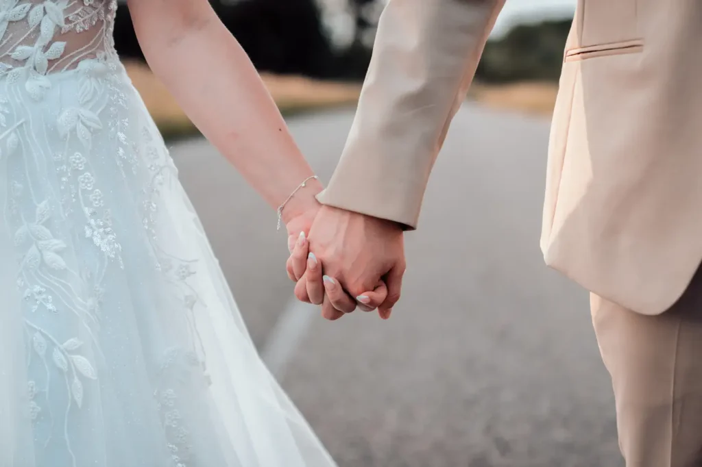 Mains des mariés enlacées au Domaine le Herre