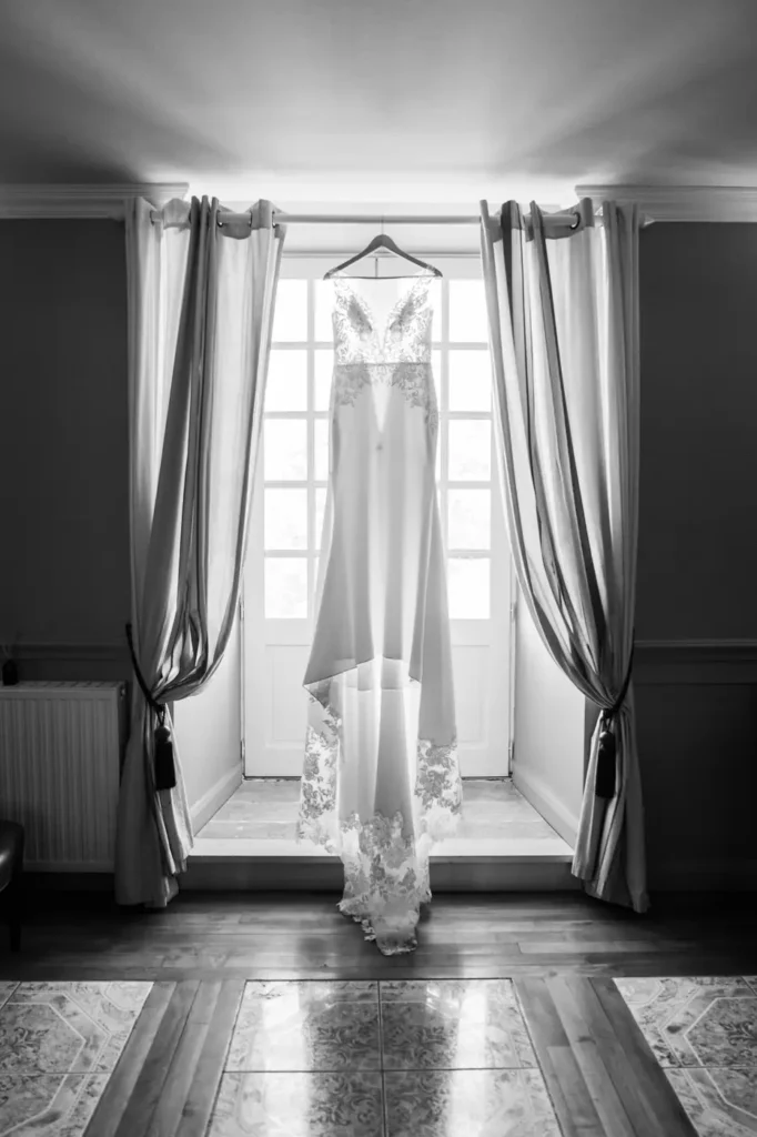 Robe de mariée en noir et blanc près d’une fenêtre