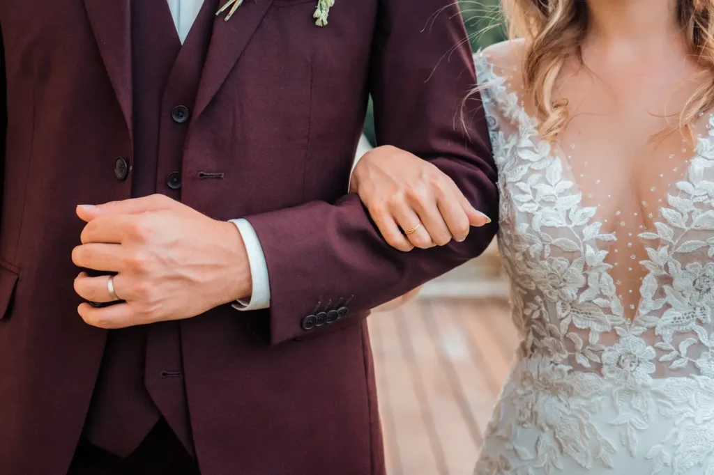 Mariés bras dessus bras dessous avec alliances visibles