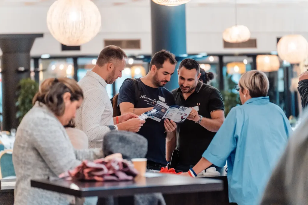 participants échangeant autour d’un stand d’accueil
