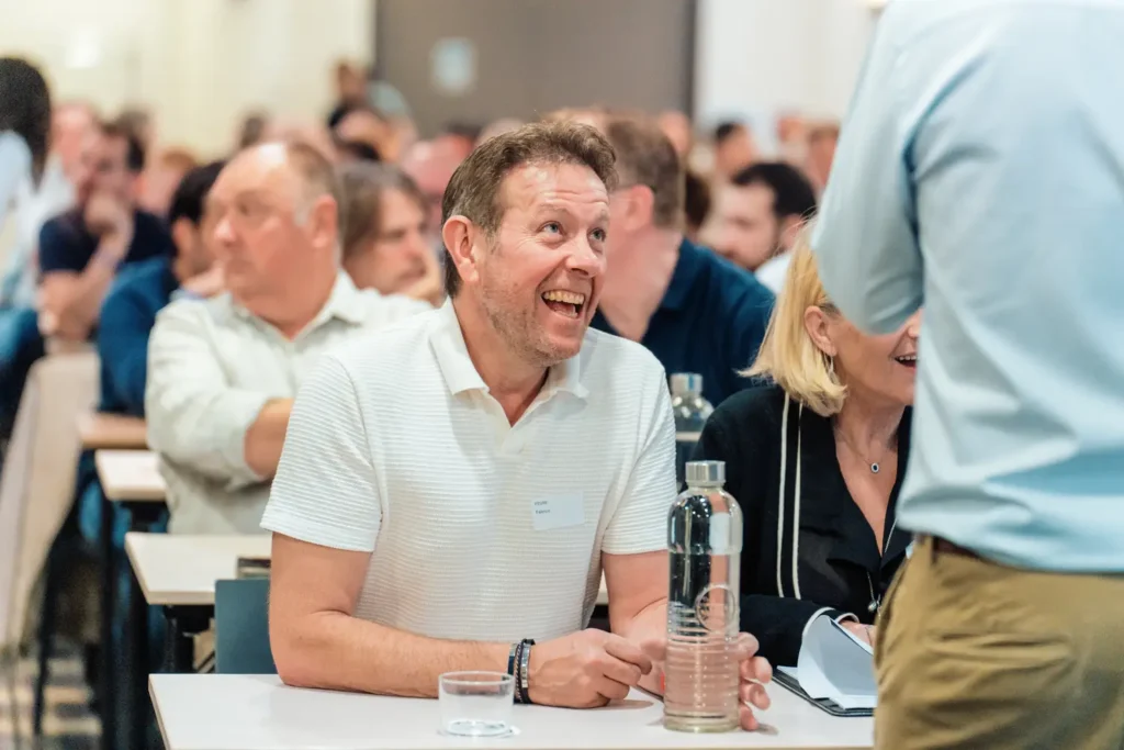 participant souriant échangeant pendant un séminaire